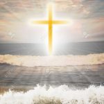 12989930-Christian-religious-symbol-cross-against-sun-shine-in-the-background-and-waves-from-the-ocean-in-the-Stock-Photo